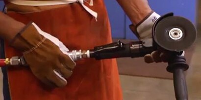 A man holds an angle grinder 
