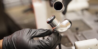 Learn about material bonding. Image of metal pipe being joined with adhesive.
