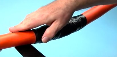 Un hombre aplica cinta aislante 3M para reparar una cubierta de cable eléctrico.
