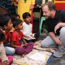 3M employee interacting with a group of Indian children during a 3M Impact - a skills based employee program