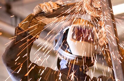 Worker using a saw while wearing a 3M Speedglas welding helmet