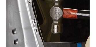 Technician completing steel panel replacement process

