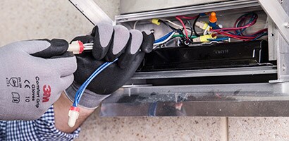 Un hombre coloca cable eléctrico con cinta 3M.
