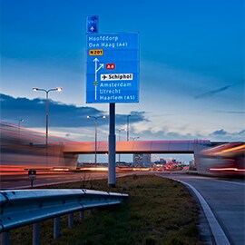 A road sign reflecting light at dusk.