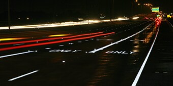 A highway at night with bright, reflective pavement markings.
