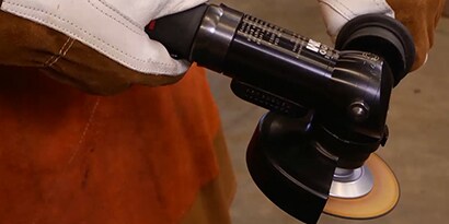 Man demonstrates the proper use of a 3M grinder 
