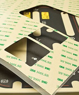 Image of a sheet of 3M™ 300 LSEAdhesive with die-cut pieces removed