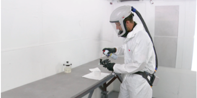 person cleaning the spray gun
