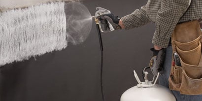 Person spraying adhesive with applicator
