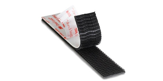 Image of a partly separated strip of 3M™ Dual Lock™ with the adhesive liner partly peeled back
