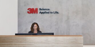 Receptionist seated at the front desk at the world headquarters entrance of 3M.
